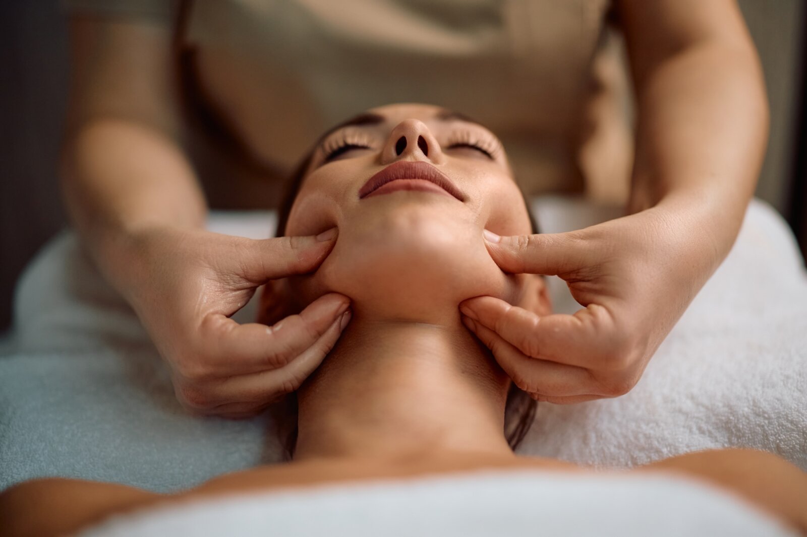Close up of woman during facial massage at beauty spa.