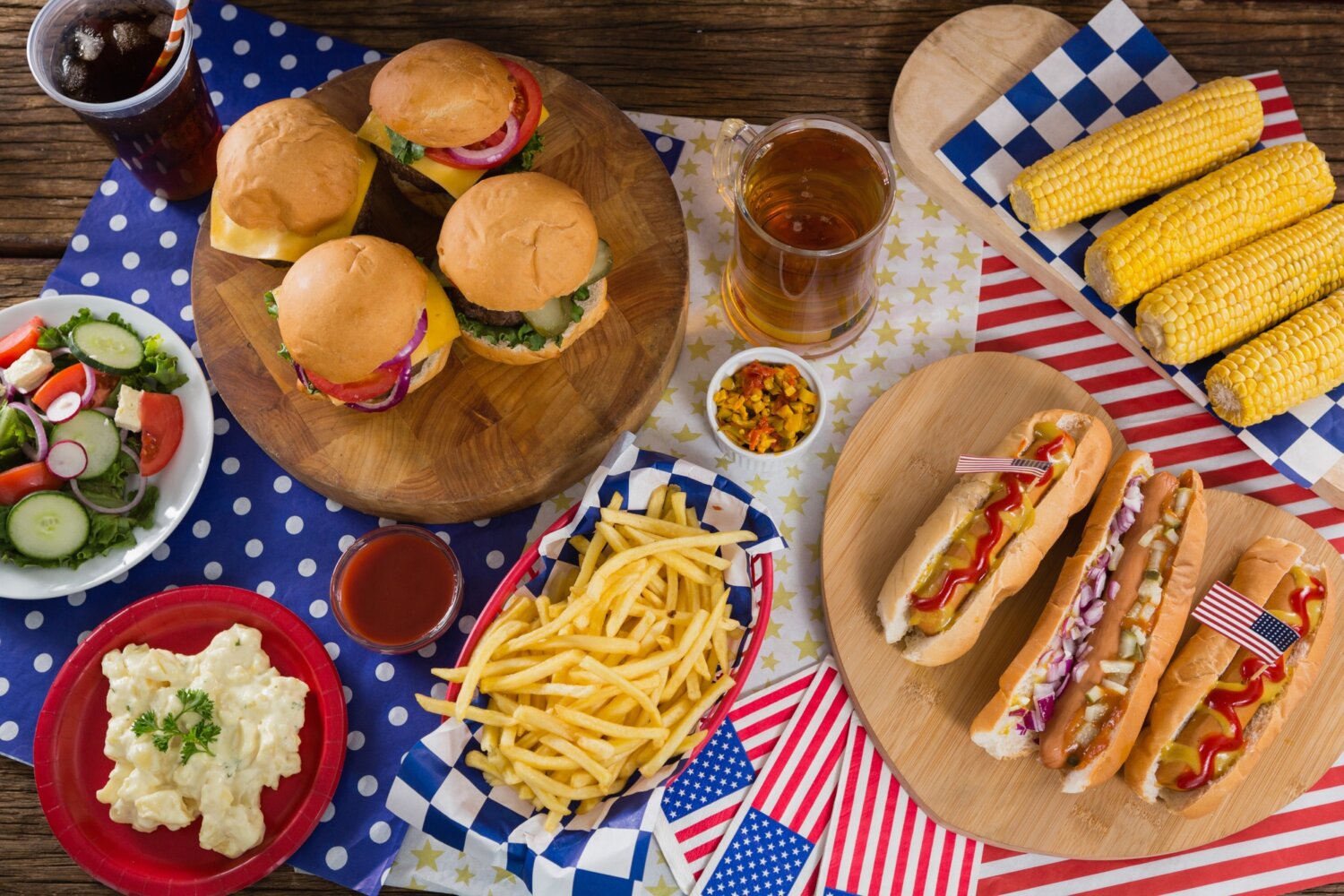 Hot dogs and burgers on wooden table with 4th july theme